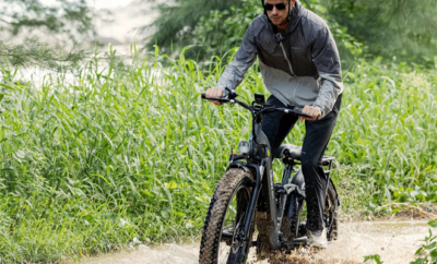 An Ebike going through a muddy puddle.