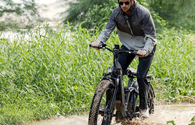 An Ebike going through a muddy puddle.