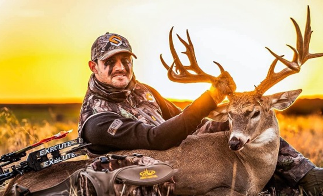 Hunter poses with whitetail buck.