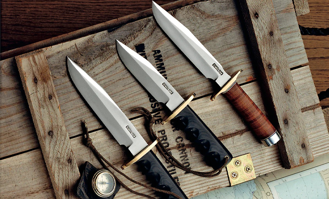 Four knives sitting on a wood box.