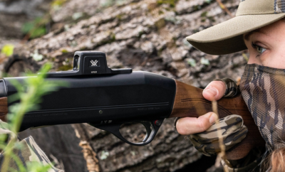 A woman holding a shotgun.