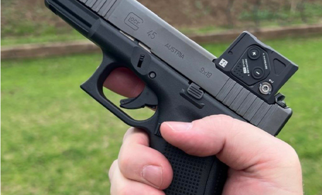 A hand gun with a red dot sight.